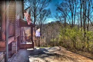 Sit on the porch and enjoy the serene forest surroundings.