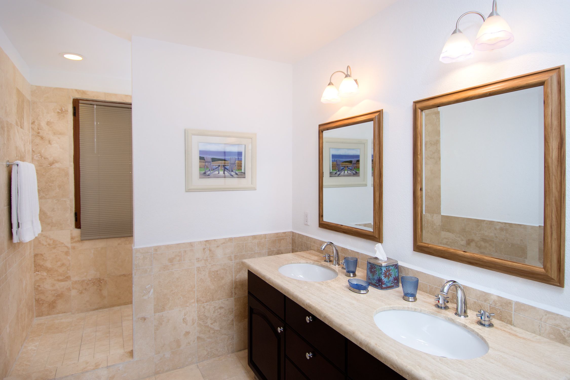 A bathroom with two sinks, a mirror, and a towel rack.
