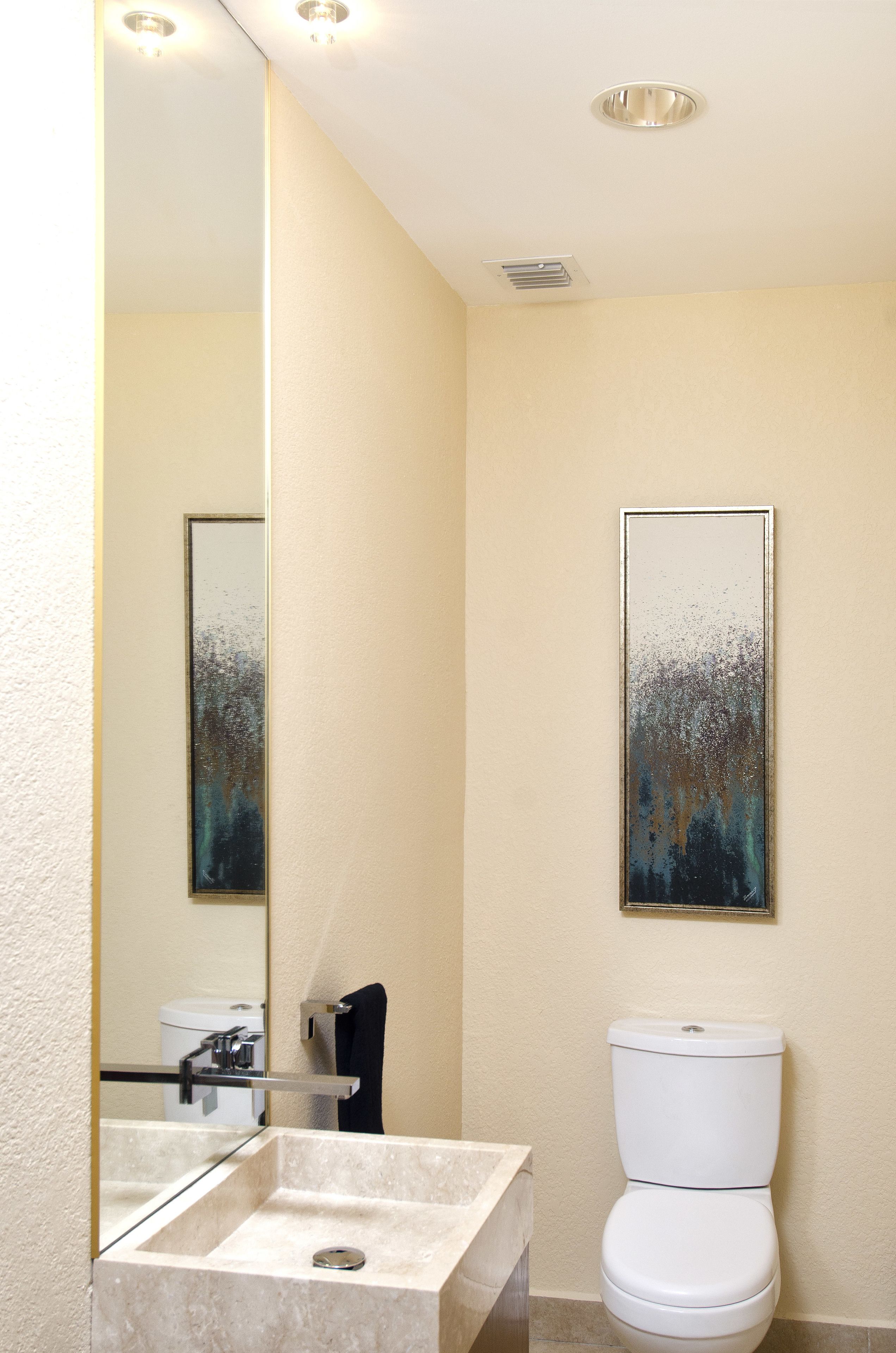 A bathroom with a large mirror, a toilet, and a sink.