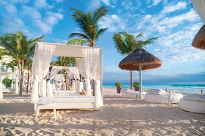 On the beach, white sand, beach umbrellas, beach towels