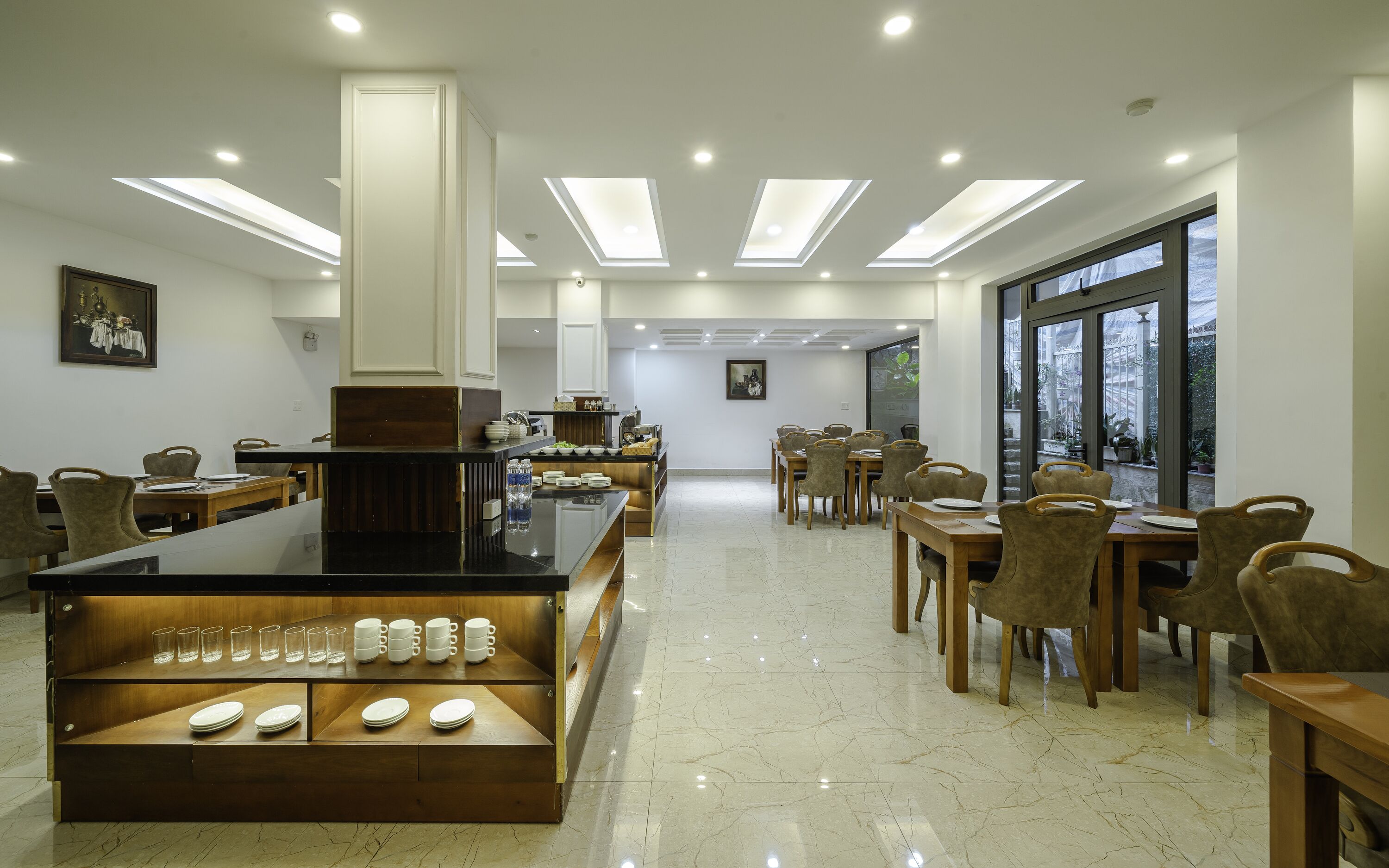 A modern dining area with a central island, multiple tables, and chairs.