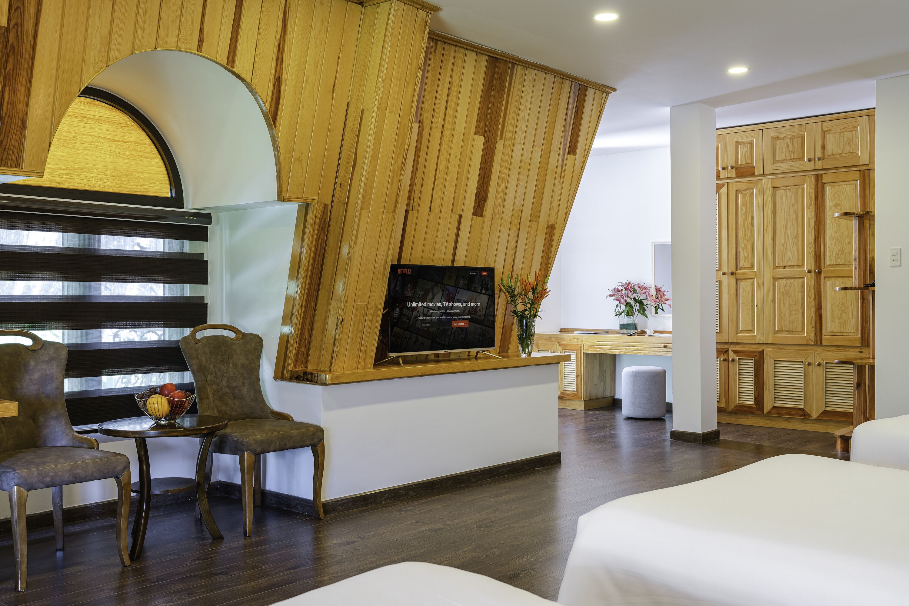 Vestíbulo de hotel con mostrador de recepción, zona de estar y paneles de madera.