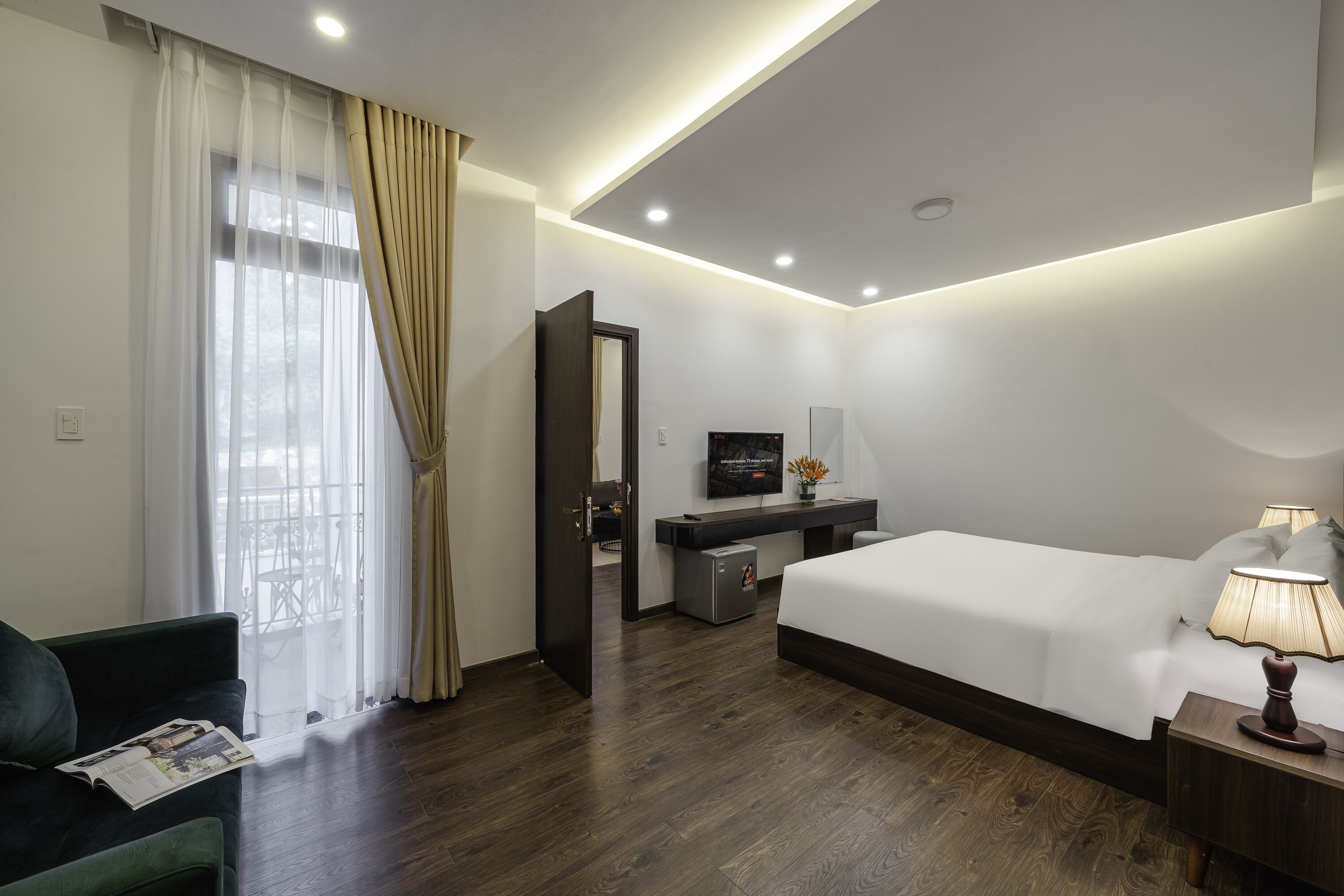 Une chambre d’hôtel avec un lit, un bureau, une télévision et une lampe.