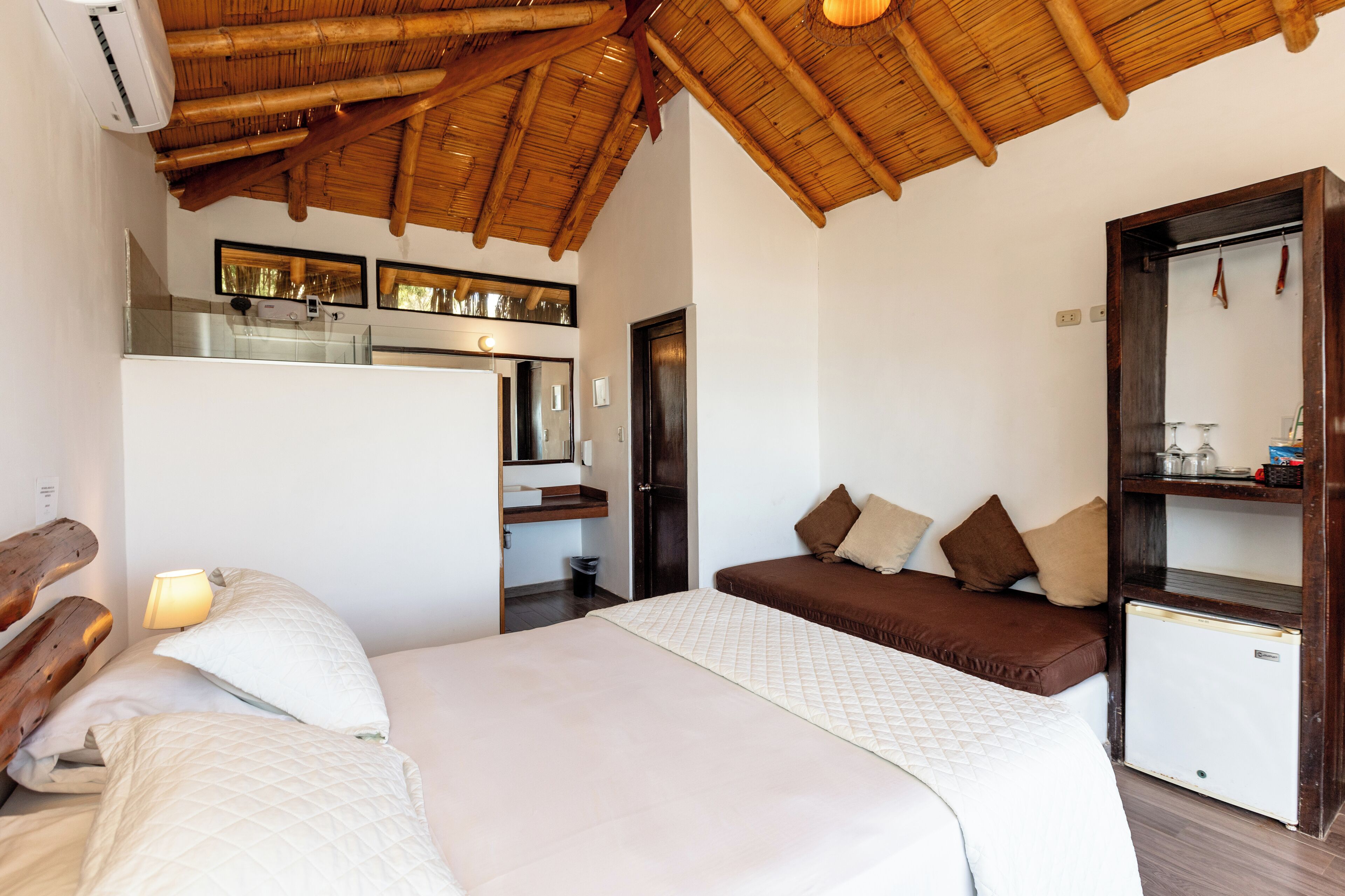 Een slaapkamer met een bed, nachtkastjes, een kledingkast en een plafondventilator.