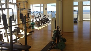 A gym with cardio machines, weightlifting equipment, and a bench. - Radar Cabo Corrientes (Mar del Plata)