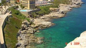 Un hôtel situé sur la côte, composé de plusieurs bâtiments, doté d’une piscine et entouré d’un paysage rocheux.