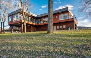 A modern two-story house with large windows and a flat roof.