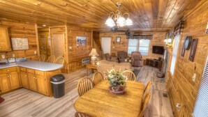 L’intérieur d’une cabane en bois comprend un coin repas, une cuisine et un espace de vie.