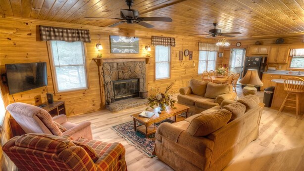 Un intérieur de chalet chaleureux avec une cheminée, des meubles en bois et un coin repas.