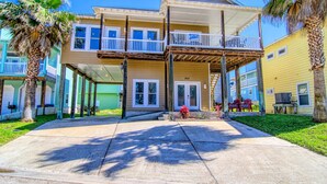 A two-story building with a covered porch and a small garden area.