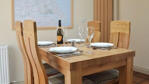 A dining table set with plates, cutlery, and wine glasses, with a map on the wall behind. - 2 bedroom accommodation in Tibthorpe, near Driffield (Tibthorpe, near Driffield)