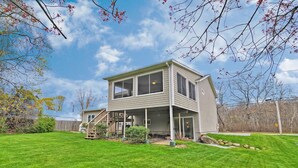 A two-story house with a covered porch, a fenced yard, and a clear blue sky. - Narragansett Pier! Easy walk to seawall, food, shopping, playground - more!  (Narragansett)