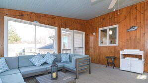 A wooden deck with a sofa, a table, and a cabinet. - Narragansett Pier! Easy walk to seawall, food, shopping, playground - more!  (Narragansett)