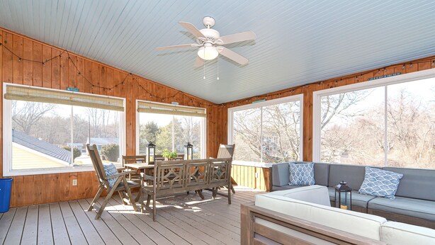 A covered deck with a table and chairs, a sofa, and a ceiling fan. - Narragansett Pier! Easy walk to seawall, food, shopping, playground - more!  (Narragansett)