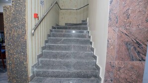 Eine Treppe mit Granitstufen und einer Handläufe, die zu einer oberen Etage führt.