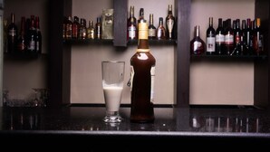 Eine Bartheke mit einer Whiskeyflasche und einem Whiskeyglas darauf.