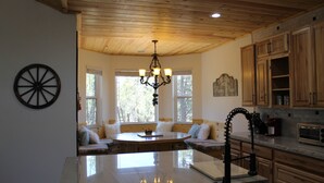 A kitchen with wooden cabinets, a marble island, and a chandelier. - Custom built cabin sitting on several acres lot in Pinetop-Lakeside! (Pinetop-Lakeside)