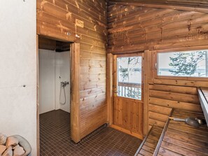 A wooden cabin interior with a shower, a door leading to a balcony, and a view of trees. - Roopenranta by Interhome (Asikkala)