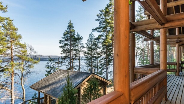 A wooden deck with a view of a lake and trees.