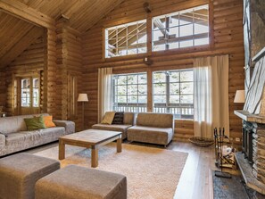 A log cabin interior with a sofa set, a coffee table, and a fireplace. - Roopenranta by Interhome (Asikkala)