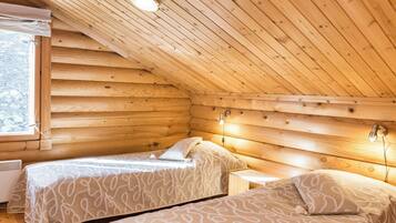A cozy cabin with two beds, a small table, and a window.