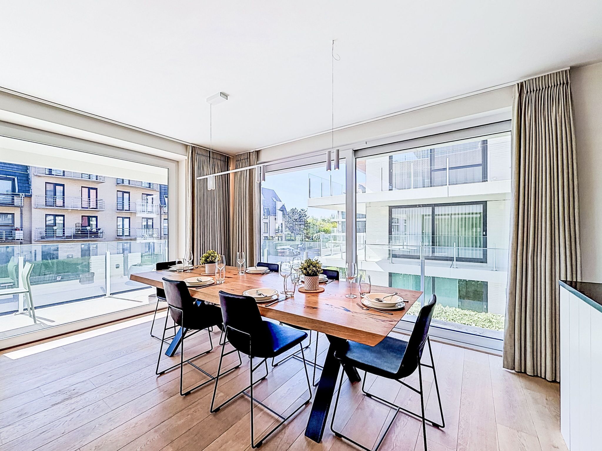 Un comedor moderno con una mesa grande, sillas y vistas a edificios.