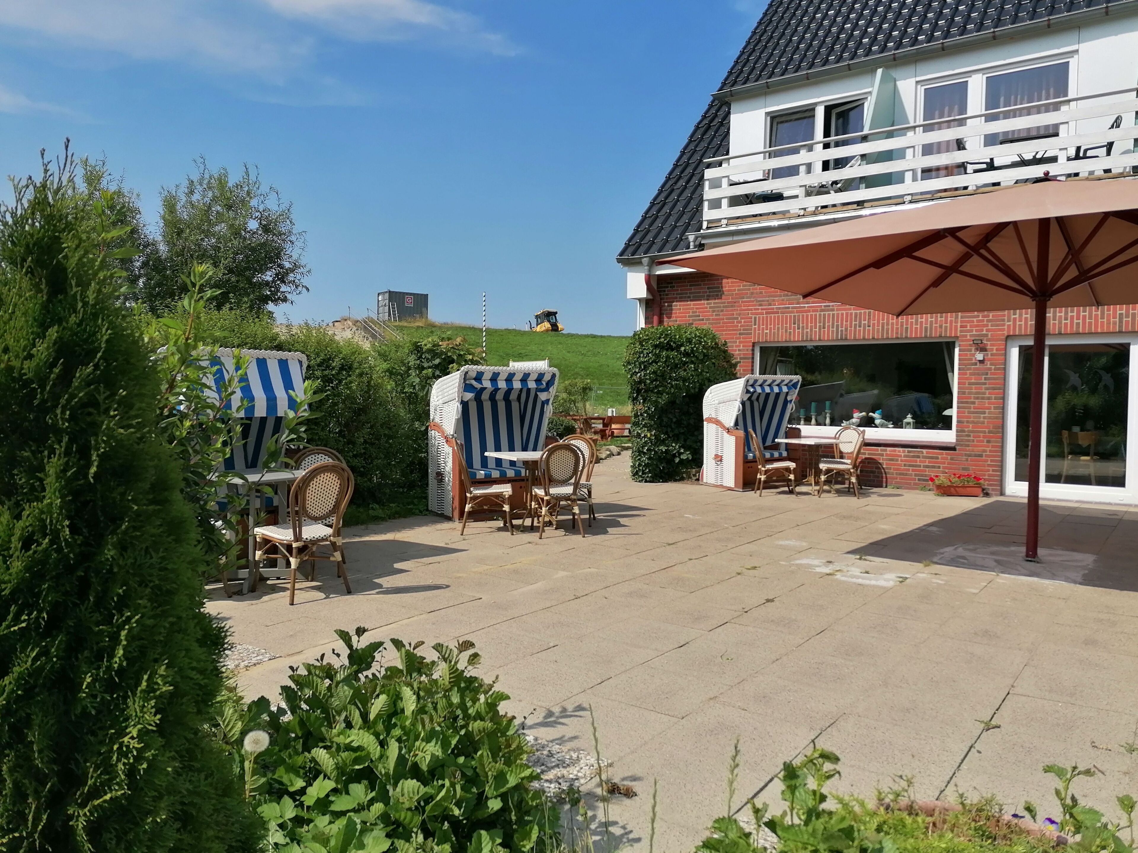 A patio area with outdoor furniture, a covered seating area, and a view of a hill.