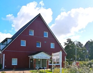 A red building with a triangular roof, labeled "Hotel Møven Kieker."