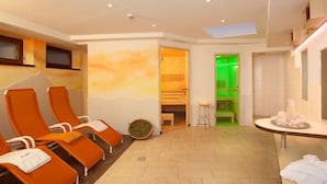 A spa room with orange chairs, a green-lit sauna, and a skylight. - Apartment Alpin by Interhome (Sölden)