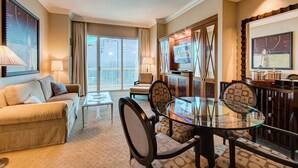 A hotel room with a living area, dining table, and a TV. - TOP 38th  FLOOR 1 BR PENTHOUSE! BALCONY! SPHERE, F1 Views, POOL-NO RESORT FEES! (Las Vegas)