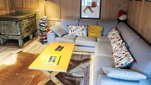 A cozy cabin interior with a sofa, a small wooden chest, and a lamp. - Feu de Joie by Interhome (Segnas)