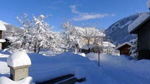 A snow-covered mountain village with wooden buildings and a clear blue sky. - Feu de Joie by Interhome (Segnas)