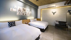 A hotel room with two beds, a brick wall with a mounted deer head, and a series of framed pictures on the wall. - Peng Hu 616 B&B (Magong)