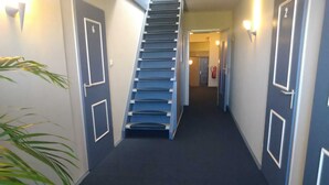 Un pasillo con una escalera que lleva a una puerta marcada con el número 6.