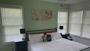 A bedroom with a large bed, two bedside tables, and a ceiling fan. - 3 BR Walking Distance to ATT, Globe Life & Entertainment District (Arlington)