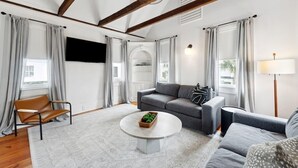 A modern living room with a sofa, armchair, and a round coffee table.