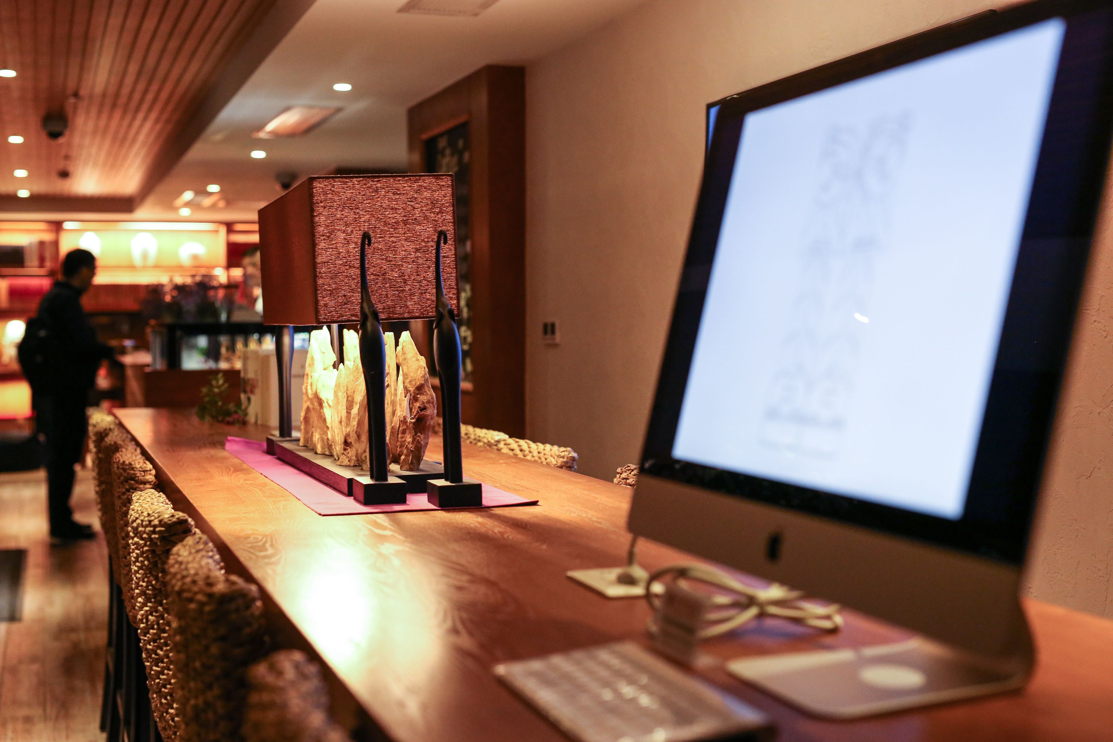 A wooden reception desk with a computer monitor, keyboard, and mouse.