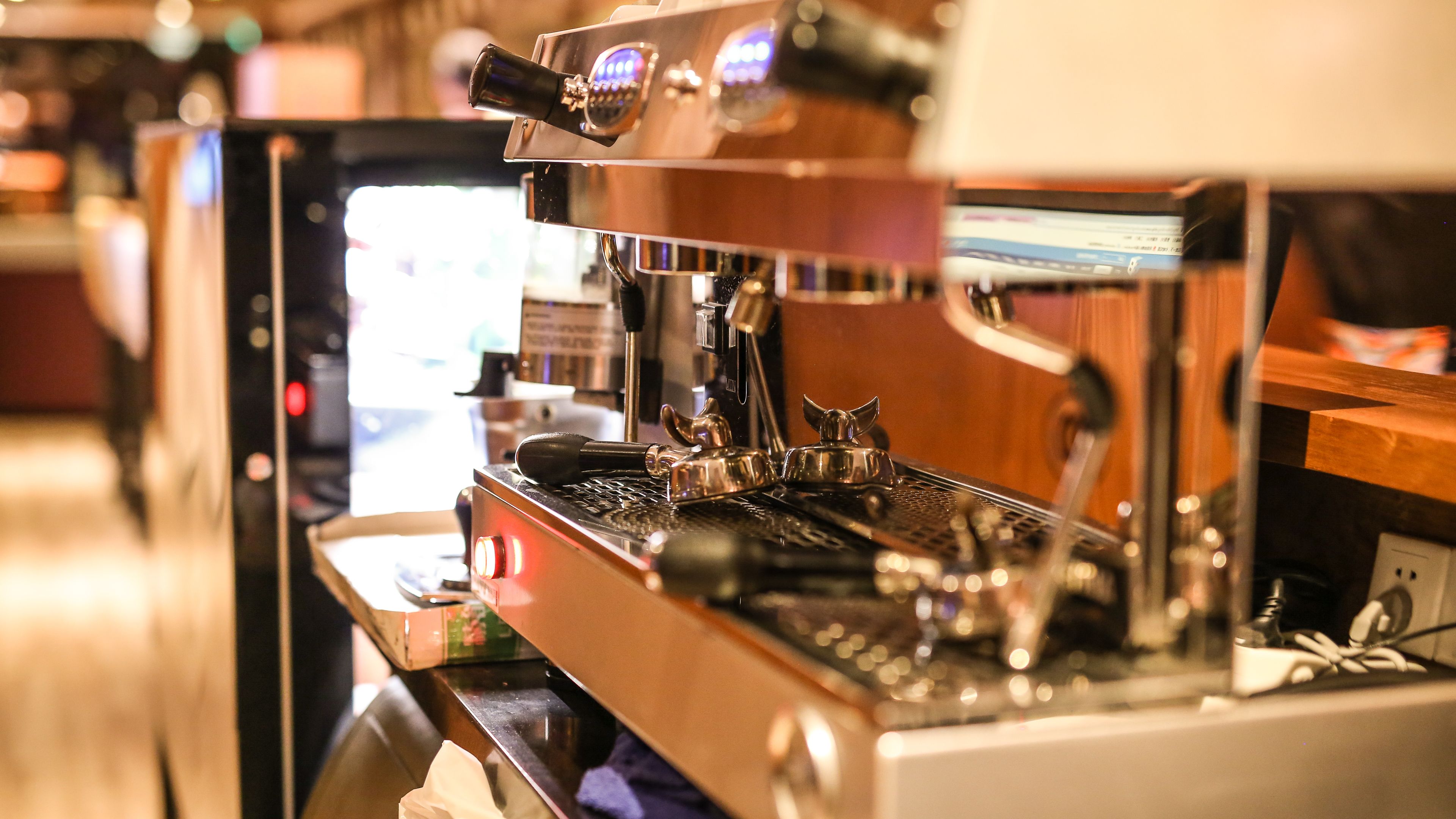 A coffee machine with a digital display and a steam wand.