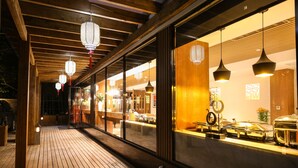 A wooden deck with a buffet setup and hanging lanterns. - SSAW Boutique Hotel Shanghai Yilin (Shanghai)