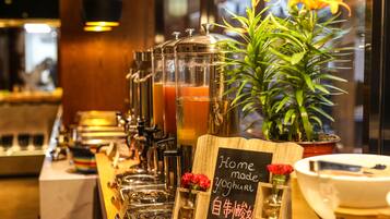 Un espace bar doté de plusieurs distributeurs de boissons, une pancarte indiquant « Yaourt fait maison » et une plante en pot.