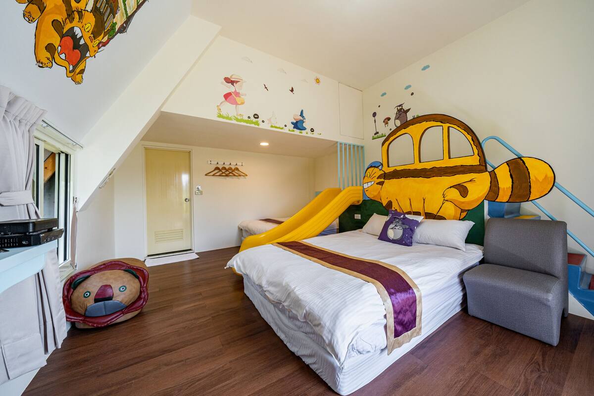 A child-friendly room with a bed, a play area, and a slide.