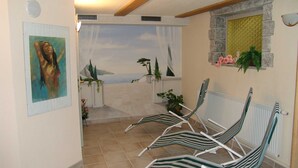 Una habitación con vistas al mar, un cuadro en la pared y una pared de piedra con una ventana.