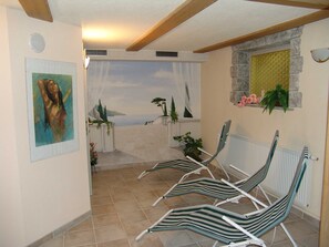 Habitació amb vista al mar, un quadre a la paret i una paret de pedra amb una finestra.
