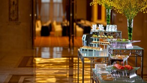 A buffet setup with various food items and a vase of yellow flowers. - Nanjing Greenland Yuhao Hot Spring Hotel (Nanjing)