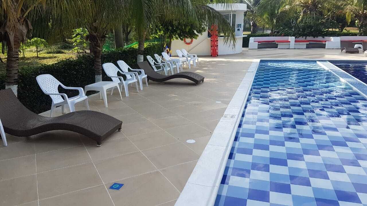 Zona de piscina con sillas de descanso y borde a cuadros.