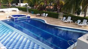 Alberca al aire libre y camastros