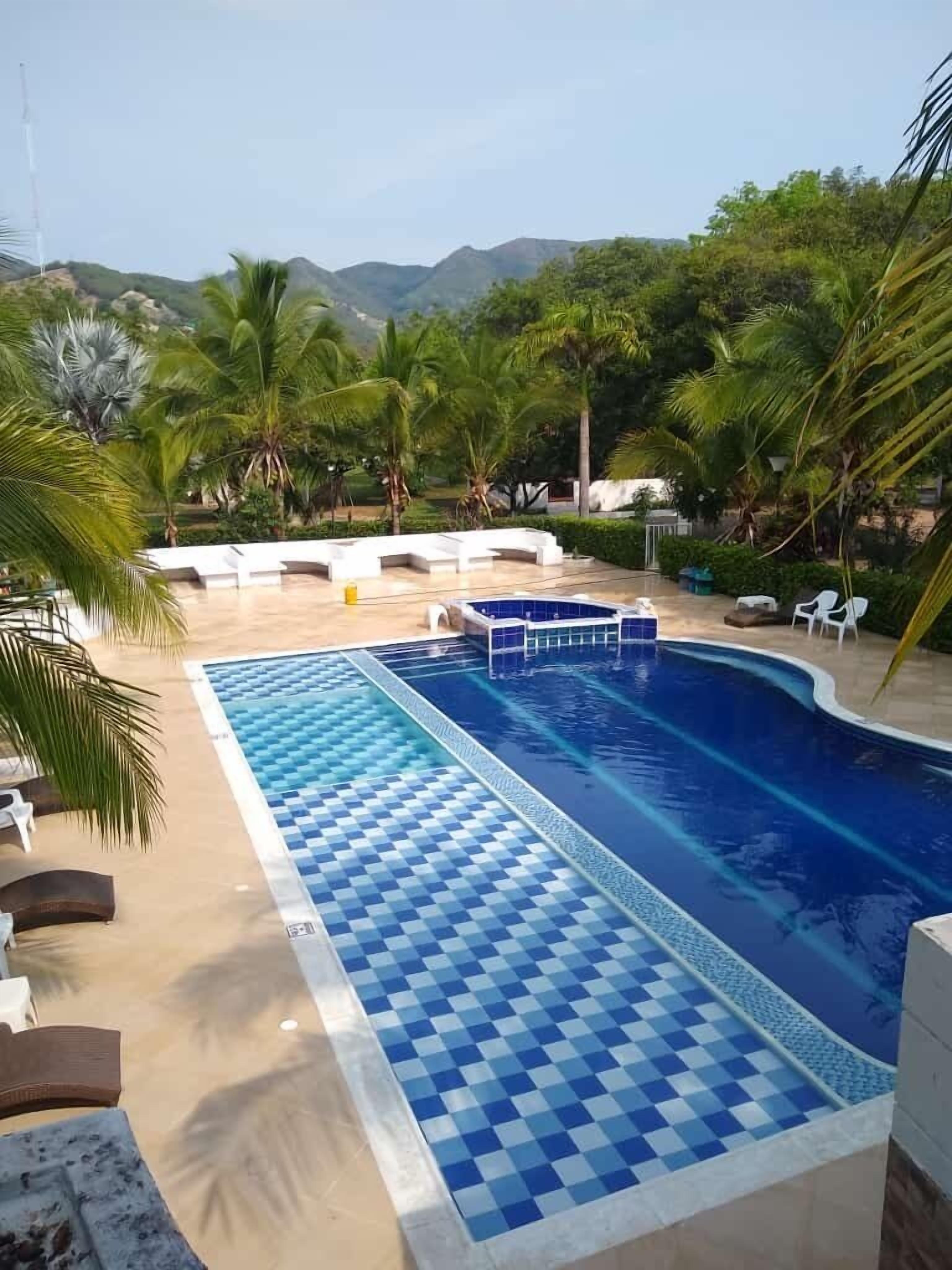 Una piscina al aire libre, sillones reclinables de piscina