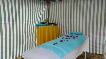 Relax in a serene, tent-like retreat with a plush bed, a small table, and a lush plant.