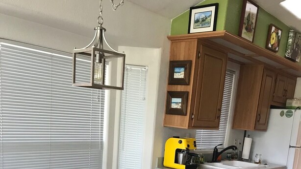 A compact kitchen with wooden cabinets, a yellow toaster, and a refrigerator.