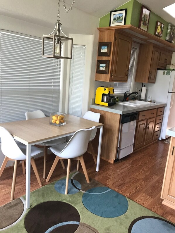 Una cocina compacta con armarios de madera, un tostador amarillo y un refrigerador.